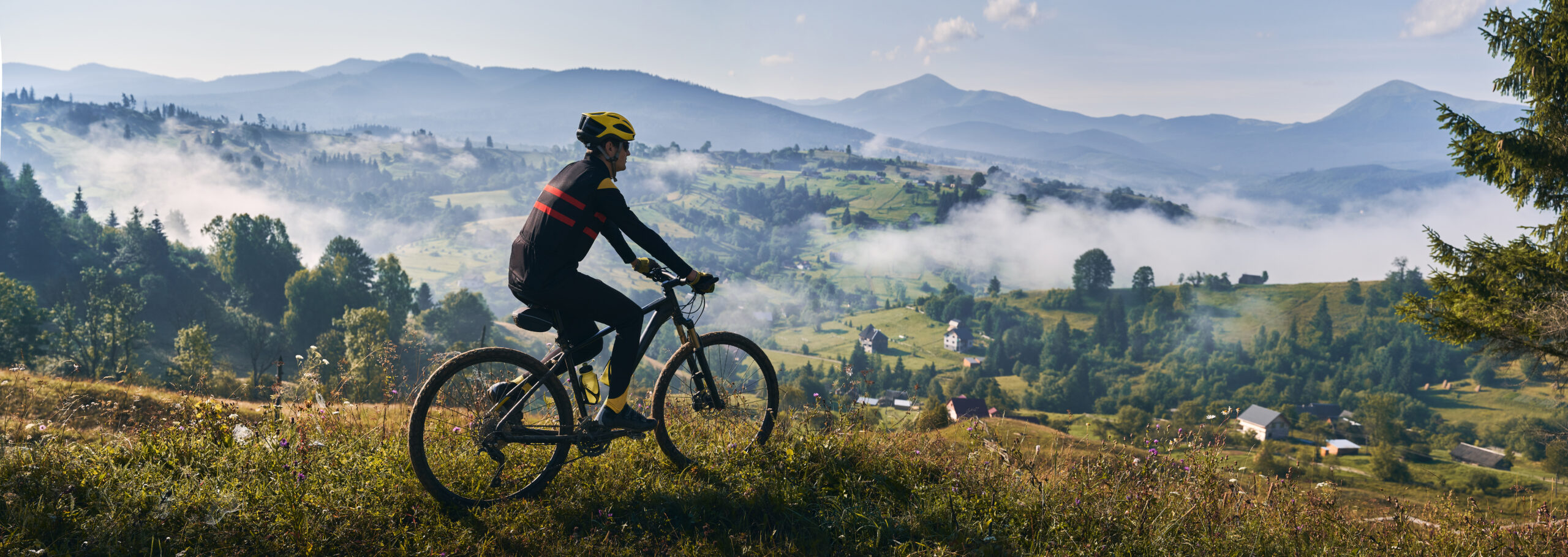 Male cyclist riding bicycle in mountains.